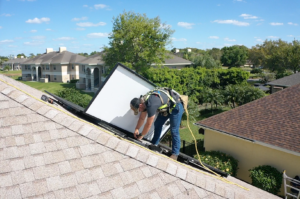 man on roof installing solar panels